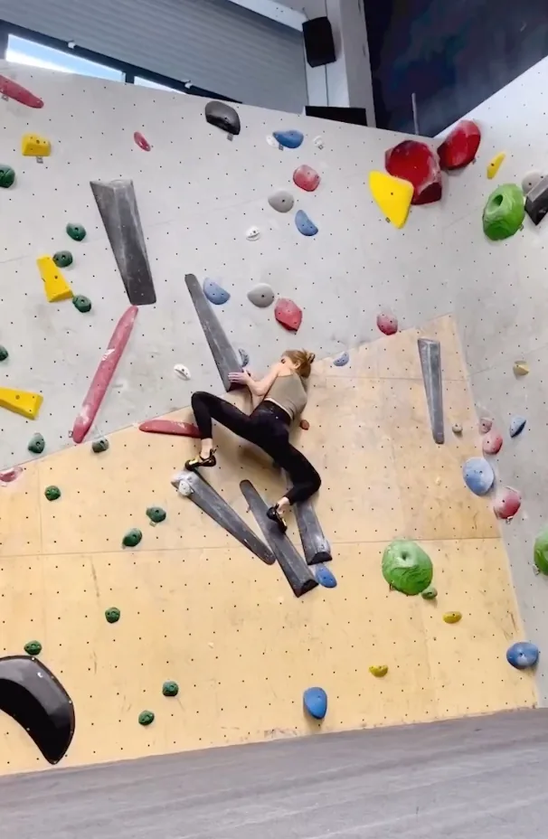 Die Boulderhalle als Drehort des Athletenporträts Die Boulderhalle als Drehort des Athletenporträts: Hannah Meul klein an der überhängenden Wand voller bunter Griffe