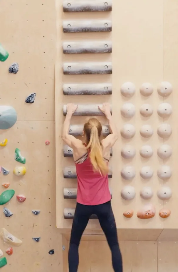 Training am Board — Athletenporträt für Allianz Hannah Meul steht am Trainingsboard und hält sich mit beiden Händen an einer der abgegriffenen Holzleisten fest