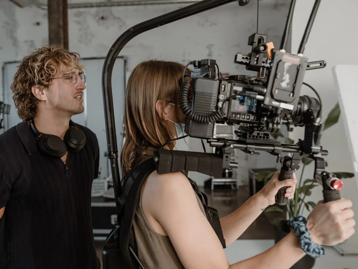 Shooting in the Le Werk studio in Cologne: two people at a camera on a body rig, one wearing headphones round the neck