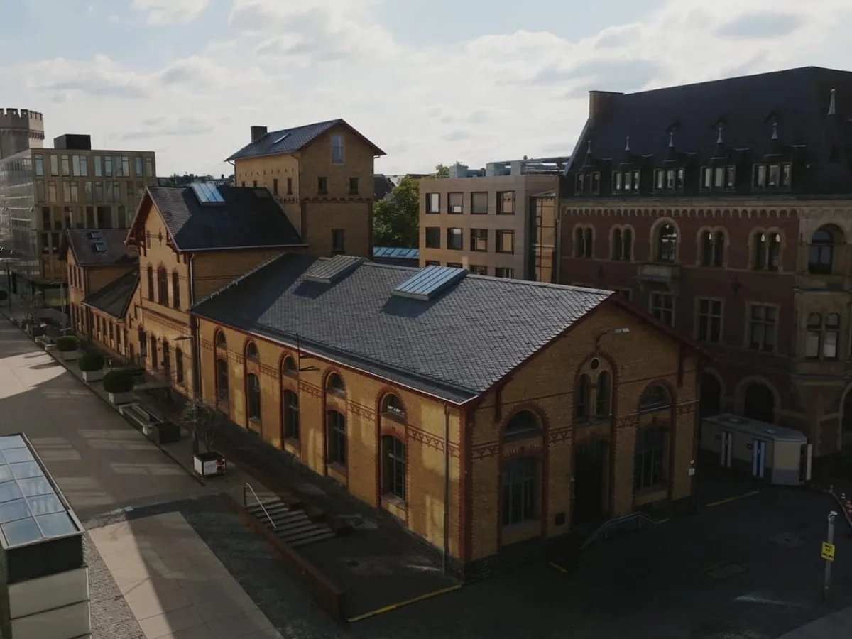 The Krafthaus in Cologne’s Rheinauhafen, home of the content creation agency Le Werk: brick building with a slate roof, cobblestones and the neighbouring buildings