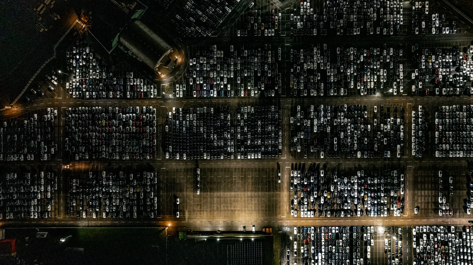 Luftaufnahme der Stellfläche bei Nacht Werksfotografie aus der Luft: dicht geparkte Neuwagen bei Nacht unter den Lichtern der Stellfläche
