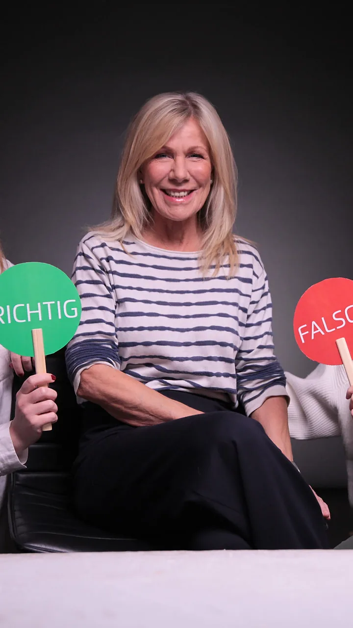 Dreh von „Richtig oder falsch": die Moderatorin zwischen zwei Frauen, die eine grüne und eine rote Tafel halten